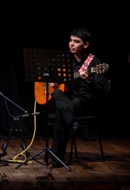 Guitarrista tocando la guitarra clásica en el escenario