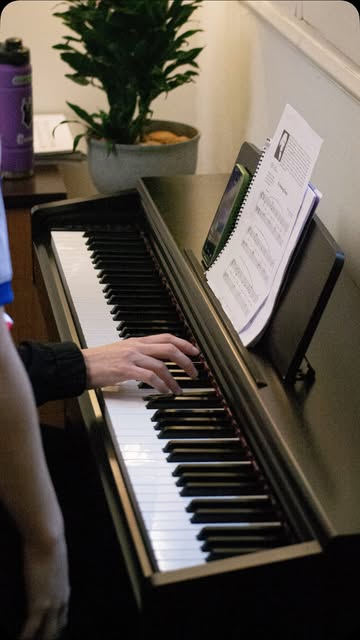 Manos tocando el piano frente a una partitura