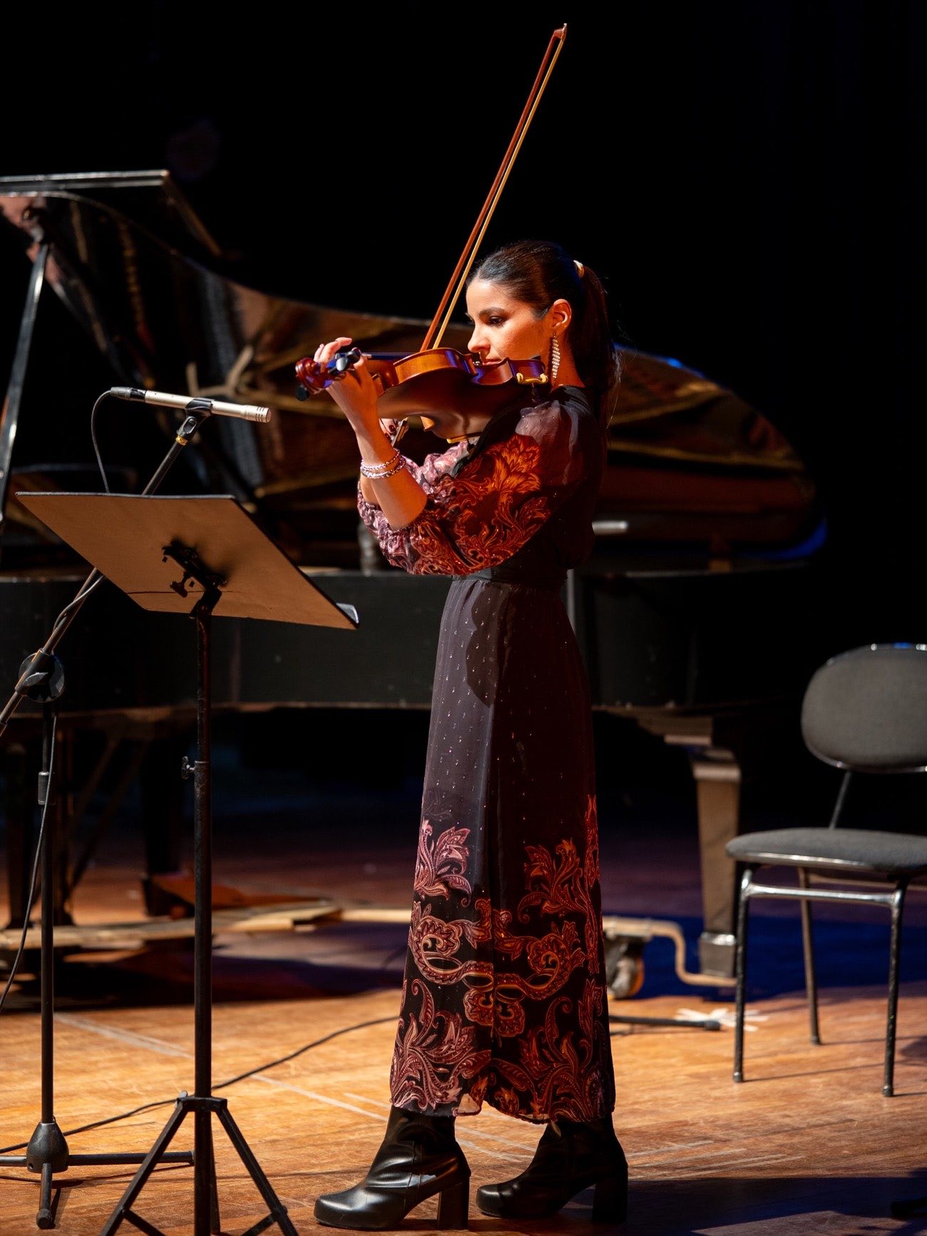 Alumna de FUSA tocando el violín en el escenario del Concierto Primavera 2026, junto a un piano de cola