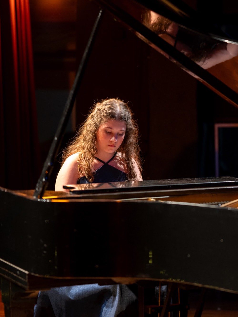 Pianista tocando un piano de cola en el escenario